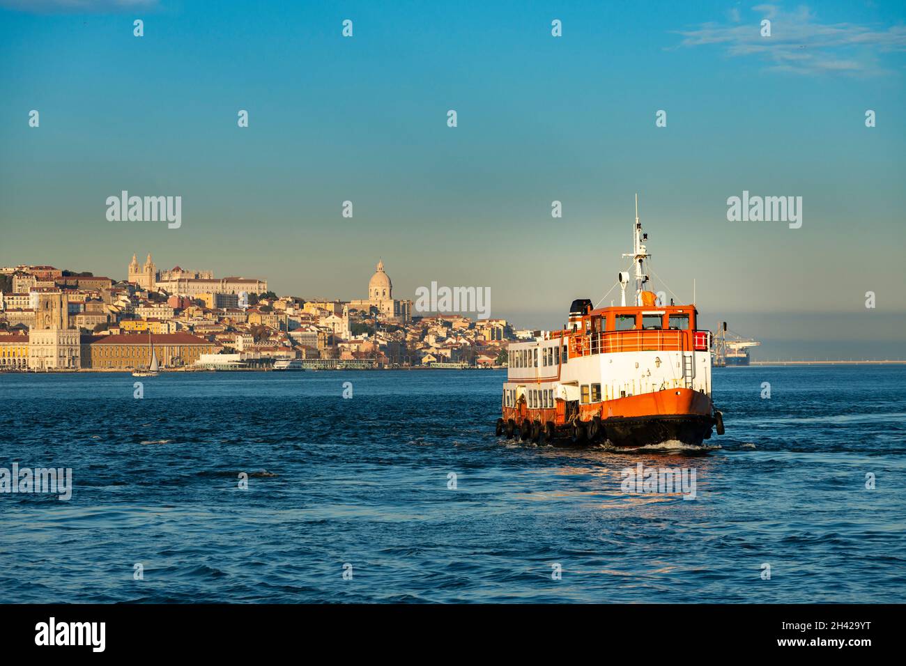 Un tradicional ferry de cacilheiro que cruza el río Tajo (Río Tejo) con la ciudad de Lisboa al fondo, en Portugal Foto de stock