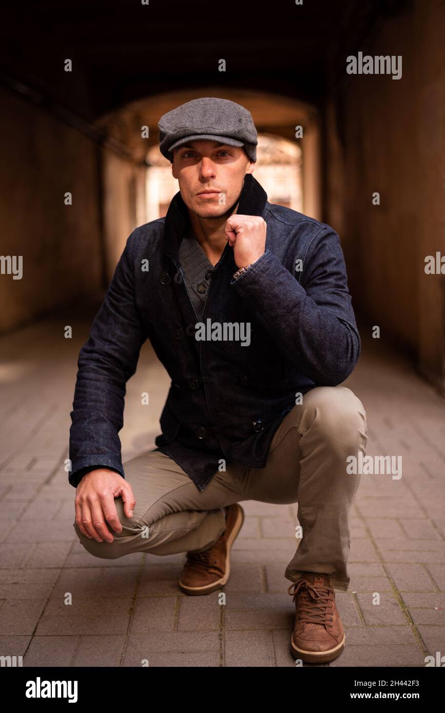 Un hombre con un abrigo y una gorra camina por la ciudad Fotografía de  stock - Alamy
