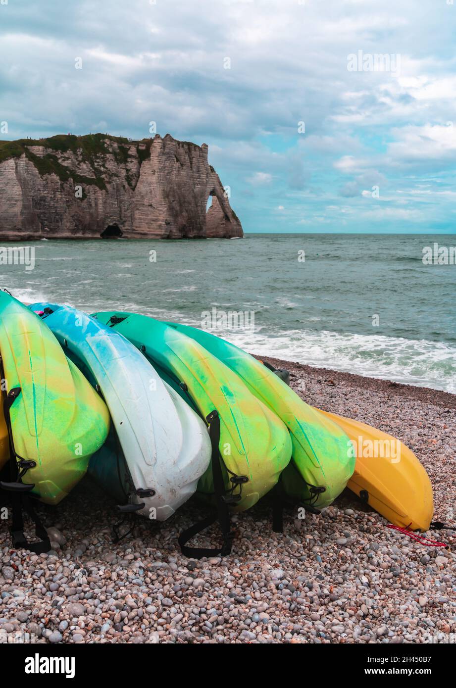Kayaks de diferentes colores apilados en las orillas del océano