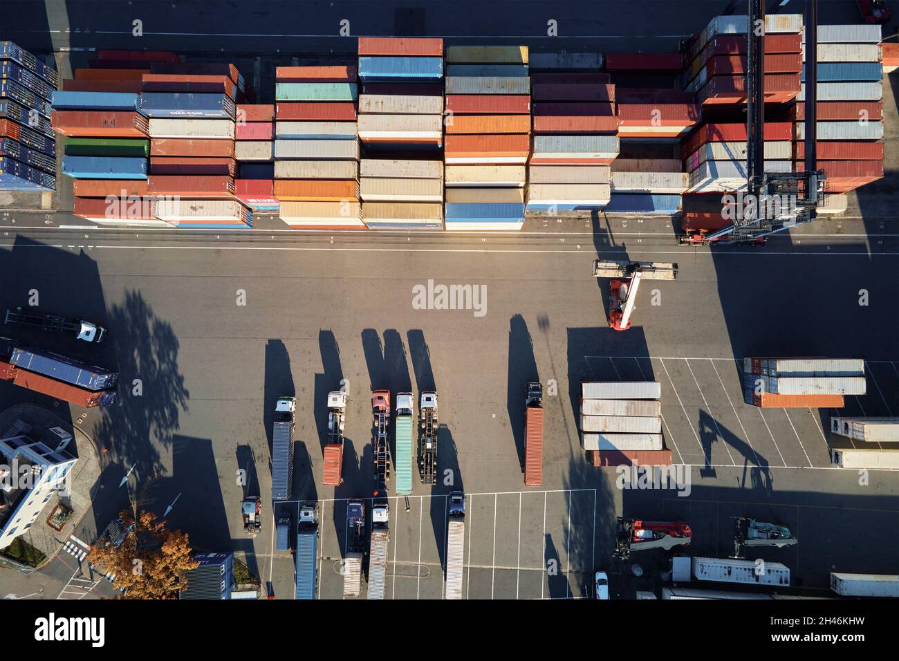 Almacén de contenedores sobre plataforma con grúas y montacargas, vista