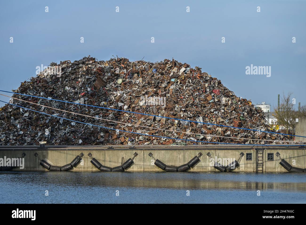 Gran montón de chatarra de metal para el reciclaje de material valioso en el muelle en el puerto de carga de Wismar en el Mar Báltico, cielo azul, espacio de copia, seleccionado Fo Foto de stock