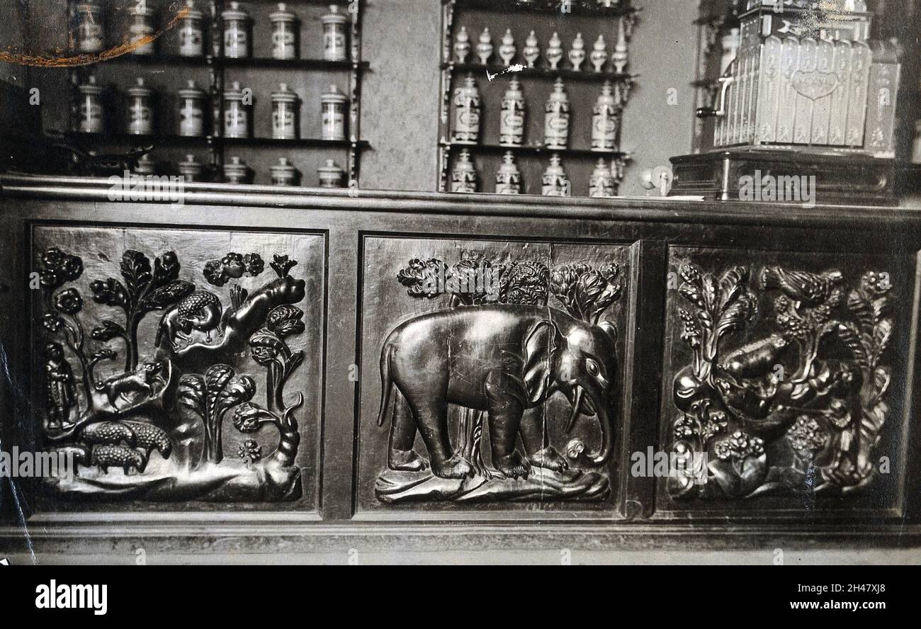 Un contador de la farmacia de madera del siglo XVII tallado en bajo relieve, el panel central es de un elefante. Fotografía. Foto de stock