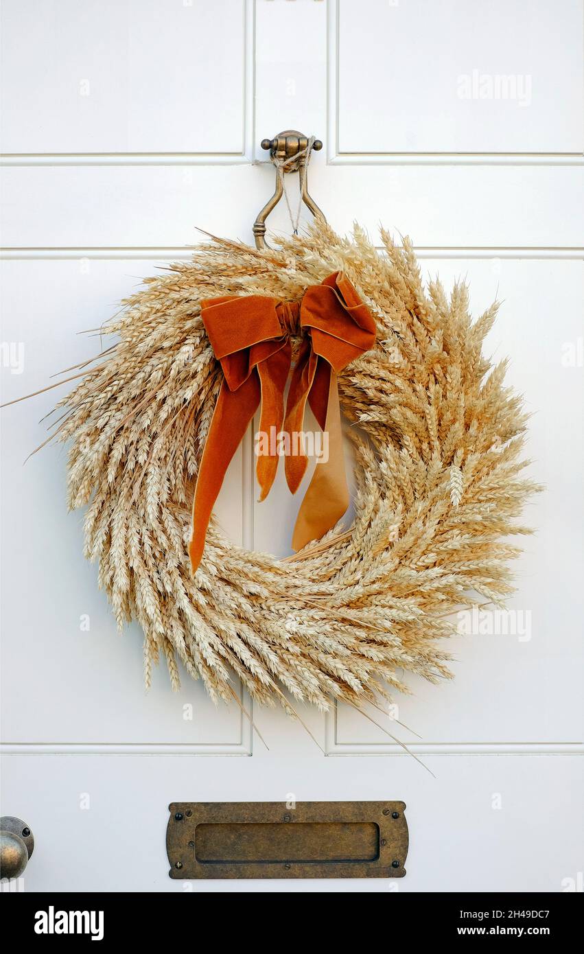 corona decorativa de estilo wheatsheaf en la puerta frontal blanca, norfolk, inglaterra Foto de stock