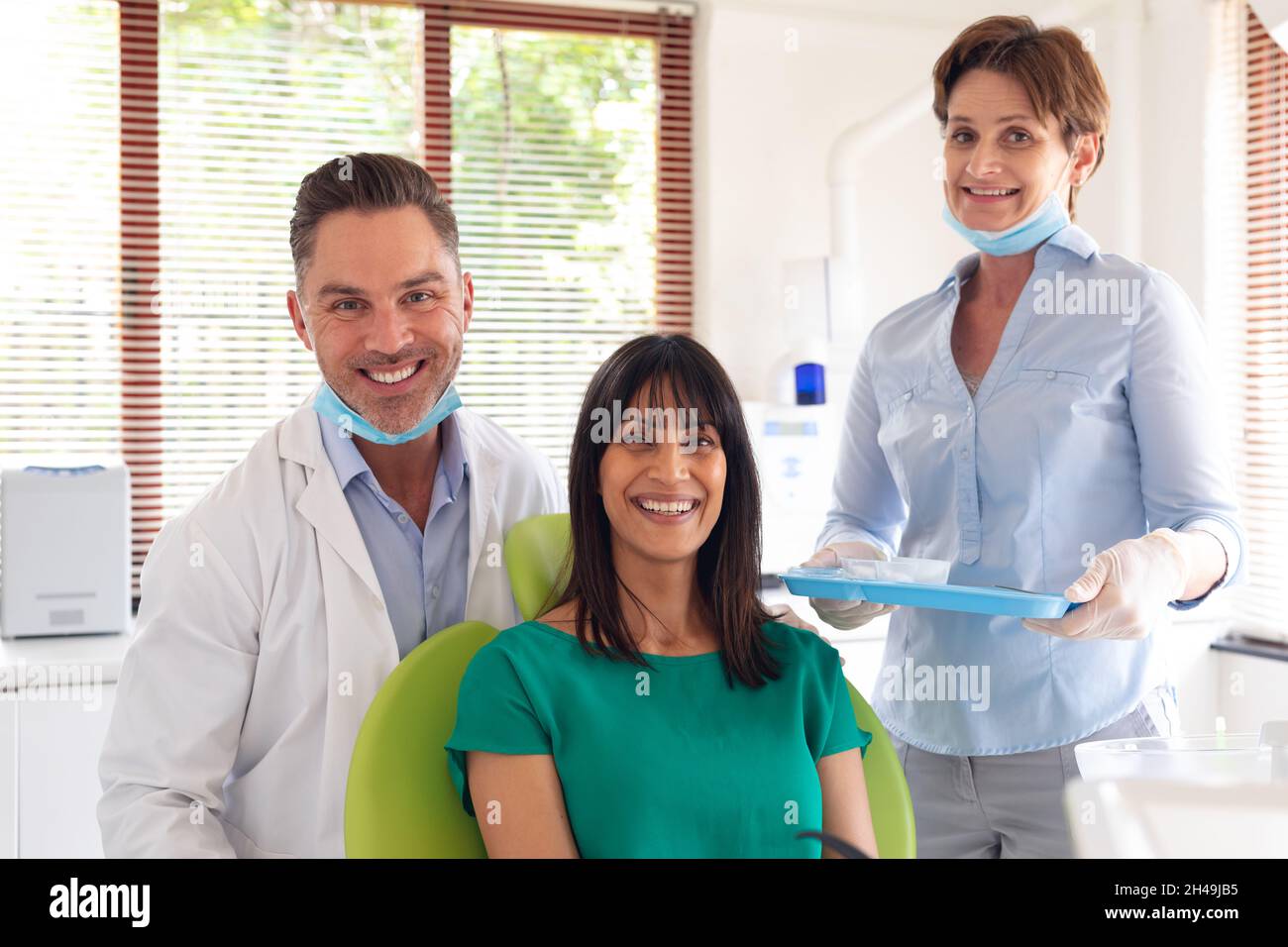 Retrato de una sonrisa diversa dentista, enfermera dental y paciente en la clínica dental moderna Foto de stock