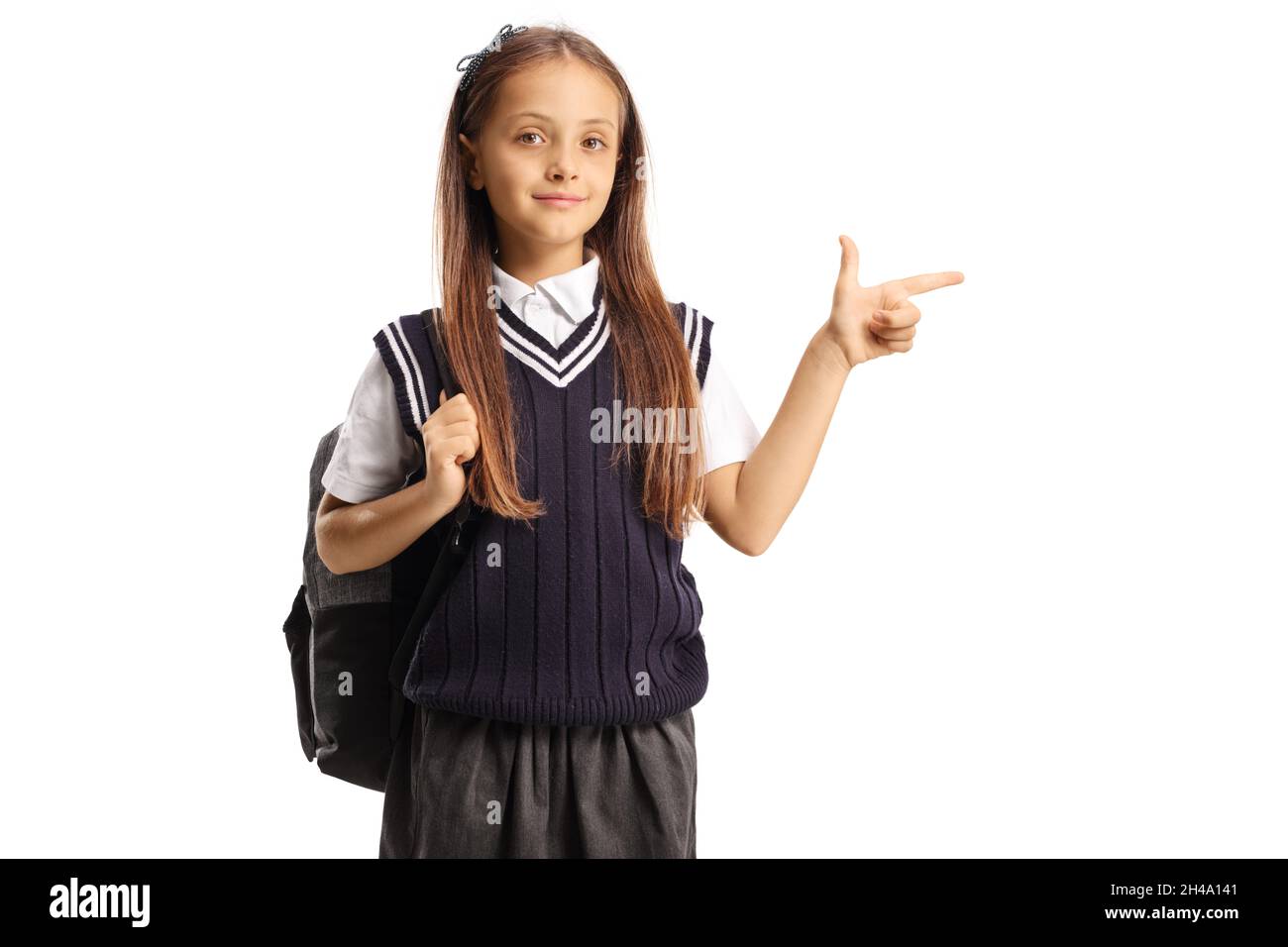 Niña en un uniforme escolar con una mochila apuntando al lado aislado sobre  fondo blanco Fotografía de stock - Alamy