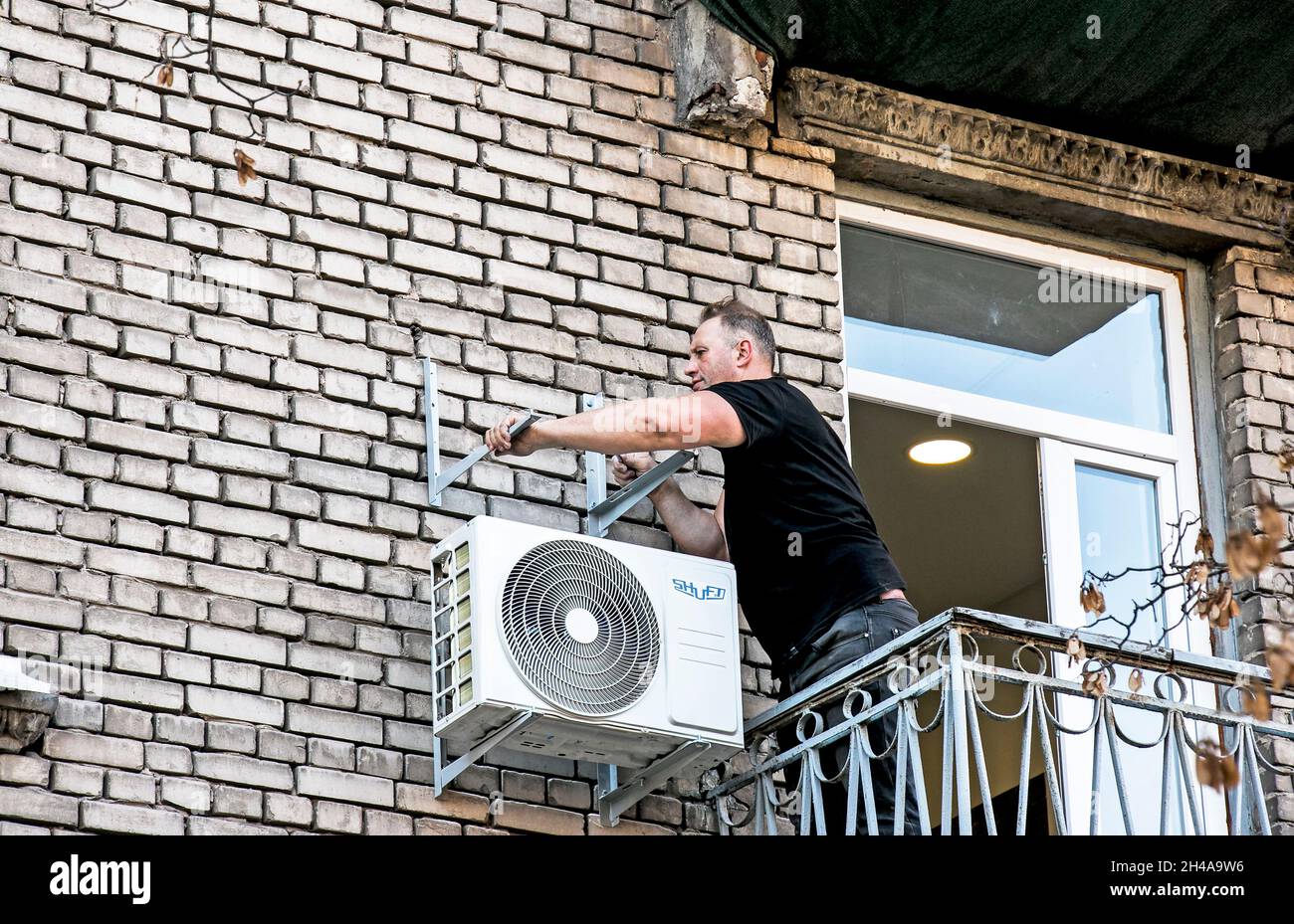 Dnepropetrovsk, Ucrania - 10.22.2021: Un trabajador instala el soporte para  la unidad exterior del aire acondicionado en la pared de la casa Fotografía  de stock - Alamy