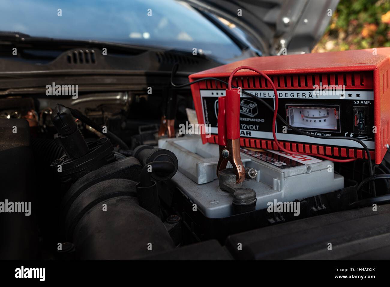 Una abrazadera roja fijada a la batería del coche para su recarga, Dinamarca, 1 de noviembre de 2021 Foto de stock