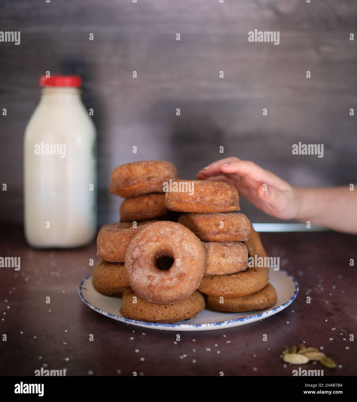 Mano del niño que alcanza para el donut de la sidra Foto de stock
