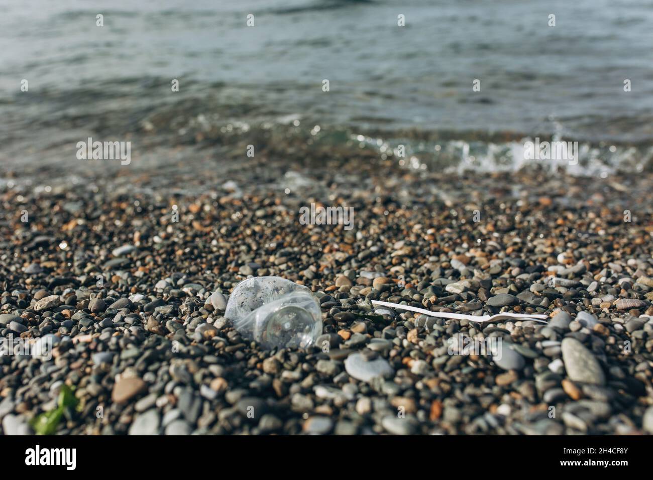 Basura de plástico en la playa del mar. El problema de la contaminación ambiental. Foto de stock