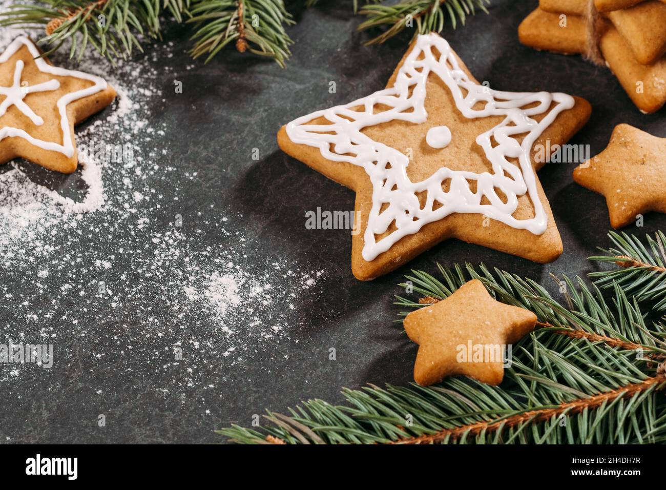 Galletas de pan de jengibre de Navidad listas para decorar con hielo, clavo aromático, jengibre, canela y rico árbol negro. Primer plano de la mesa. Estrellas y. Foto de stock