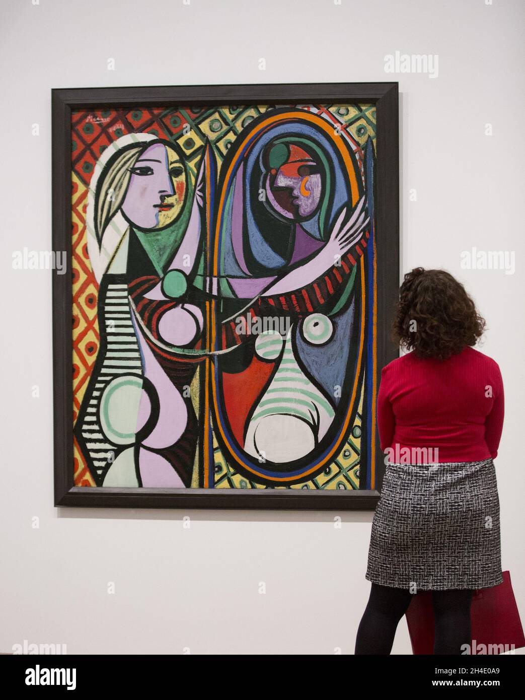 Una mujer mirando a la chica de Pablo Picasso antes de un espejo, de 1932  años, durante una vista previa de la exposición Picasso 1932 - Amor, fama,  tragedia en Tate Modern