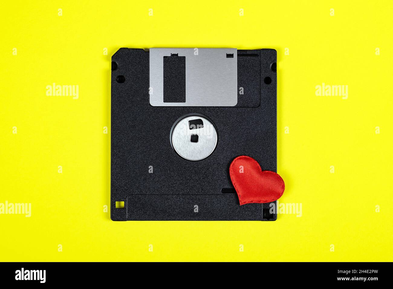Unidad de disquete con un corazón rojo en el primer plano de fondo de papel  amarillo Fotografía de stock - Alamy