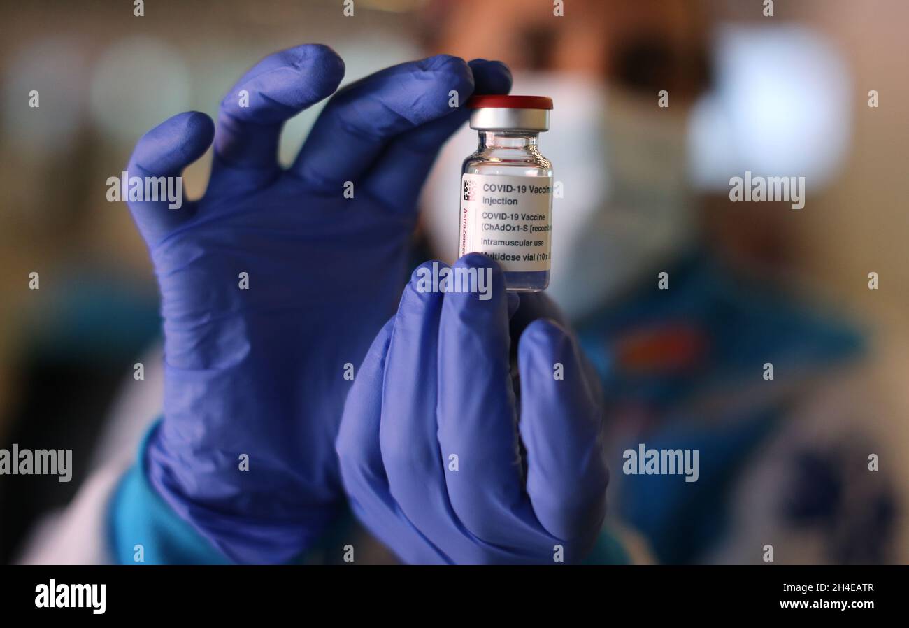 Una enfermera sostiene con manos enguantadas un vial de vacuna Covid19