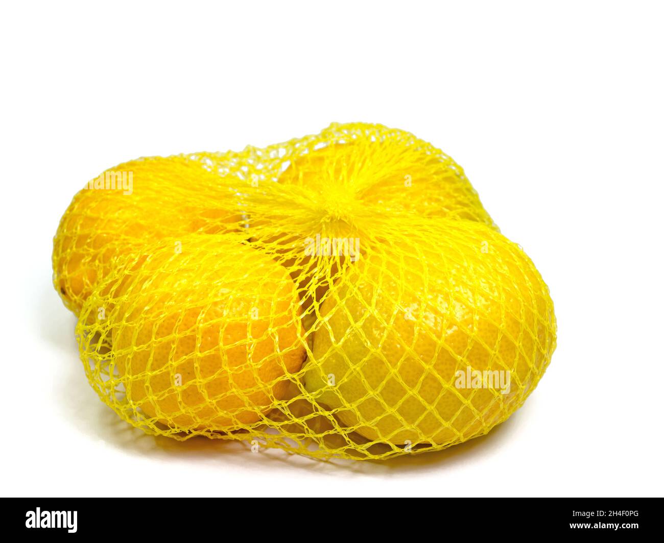 Limones en una red sobre un fondo blanco Foto de stock
