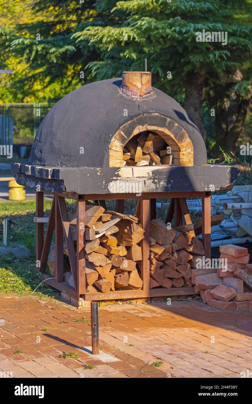 Horno de pizza grande redondo con almacenamiento de madera para incendios  Fotografía de stock - Alamy