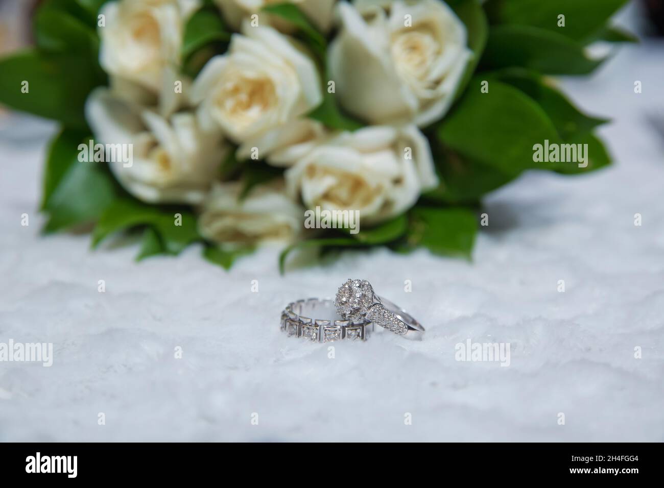 Anillos de compromiso de boda en el fondo de un hermoso ramo de rosas . Anillos de flores blancas de boda con estilo delante del ramo de la boda Fotografía de stock - Anillos de compromiso de boda en el fondo de un hermoso ramo de rosas . Anillos de flores blancas de boda con estilo delante del ramo de la boda Fotografía de stock -