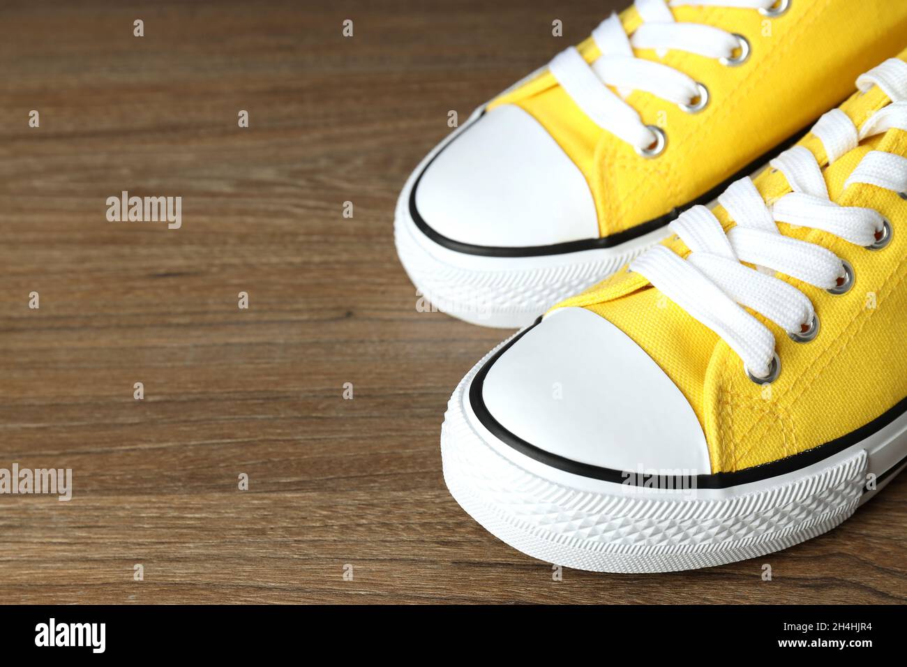Zapatillas de lona amarillas sobre fondo de madera Fotografía de stock -  Alamy