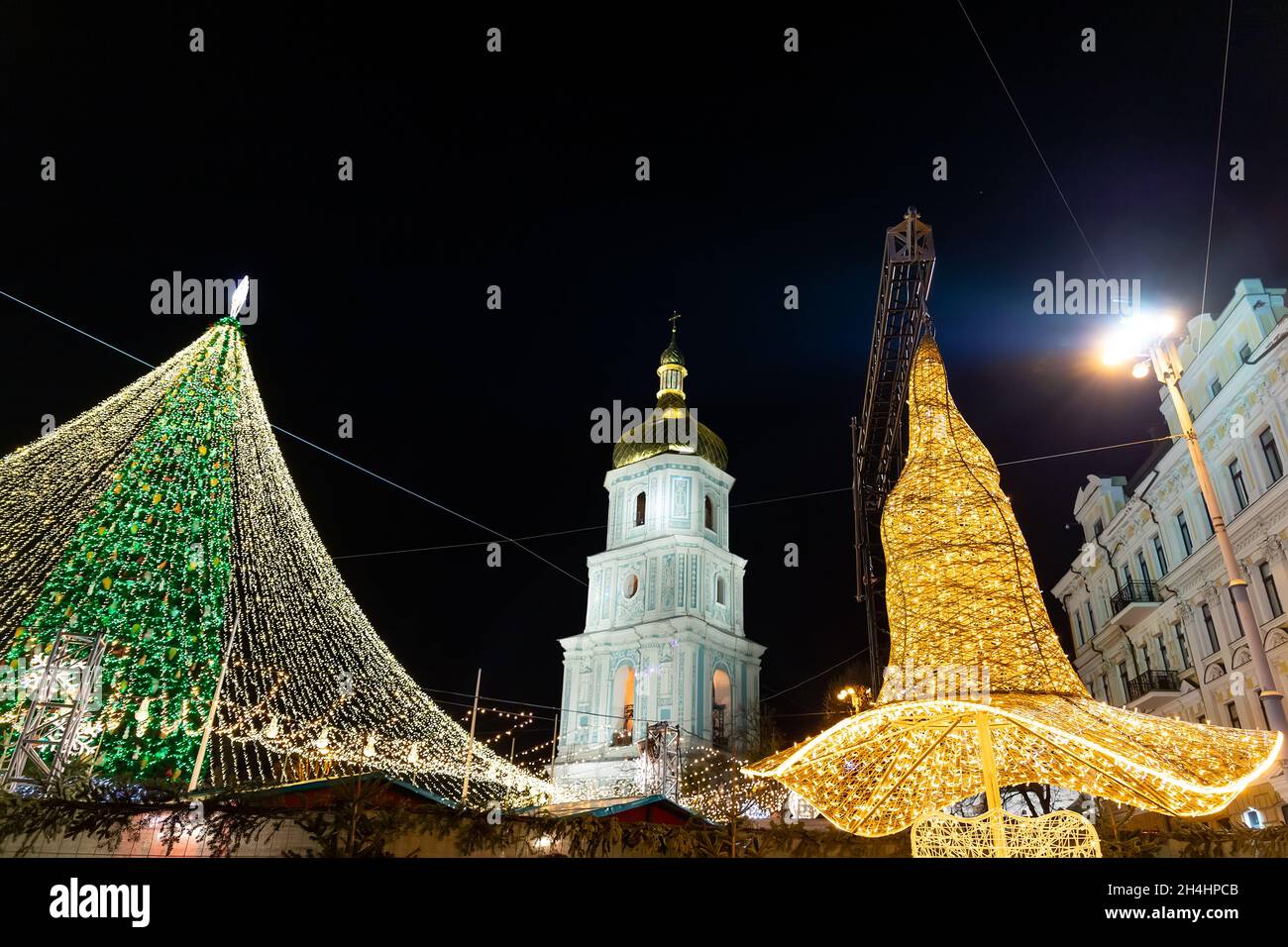 Hermoso árbol de Navidad decorado con paisajes con decoraciones e iluminado por guirnaldas claras contra la catedral de Sophia en el fondo de la plaza Sofievska Foto de stock