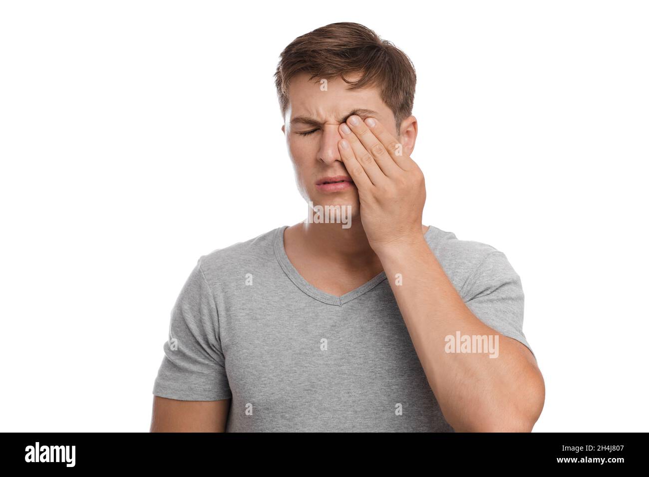 Triste cansado infeliz millennial europeo atractivo hombre frota los ojos, sufre de dolor y sequedad Foto de stock