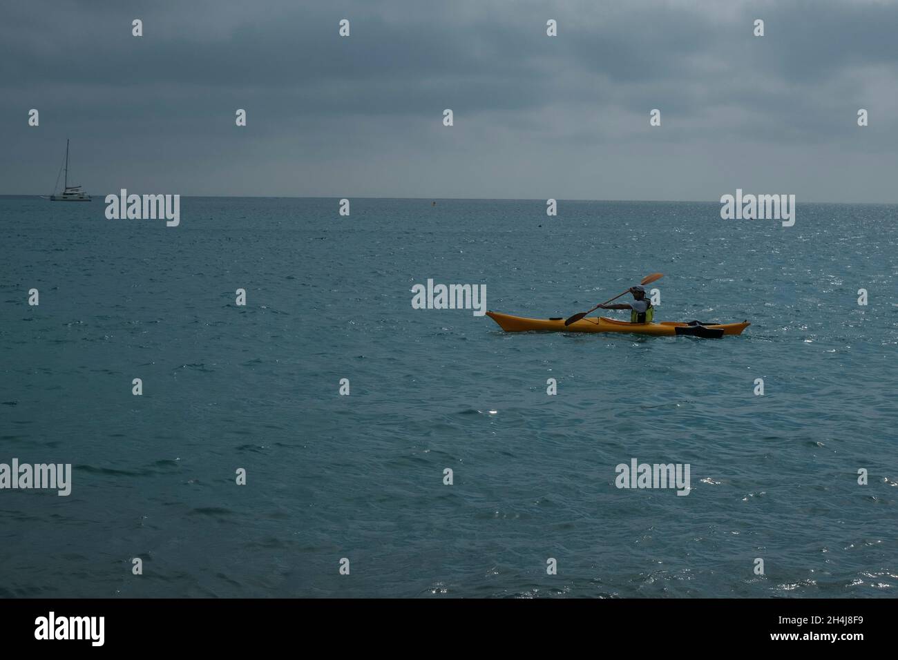 hombre kayak en el mar a través del horizonte. barco en el mar. Actividades al aire libre. Natación Foto de stock