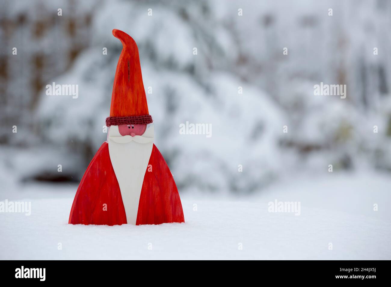 Figura de madera de Santa Claus en fondo de nieve Foto de stock
