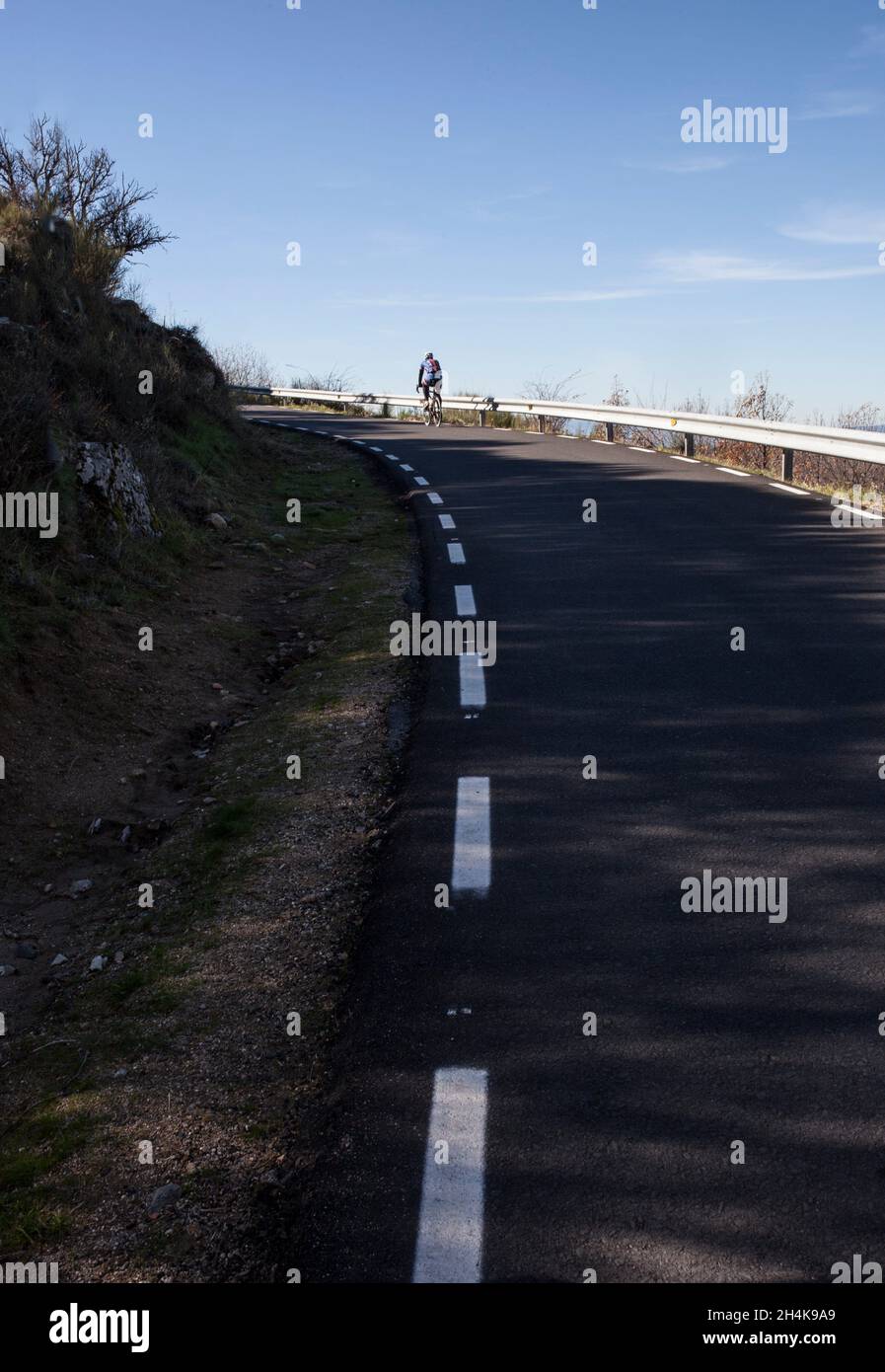 Pase de montaña ascendente maduro para ciclistas. Ciclismo de carretera por Extremadura, España. Foto de stock
