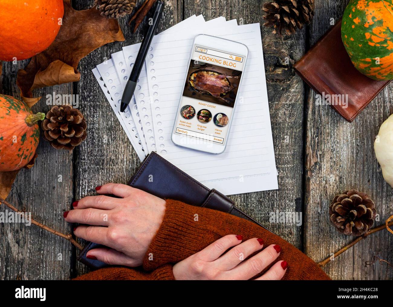 Smartphone con pantalla táctil con blog de cocina en línea en la pantalla de la mesa rústica en la cocina. Receta de Acción de Gracias. Concepto de cocina otoñal. Foto de stock