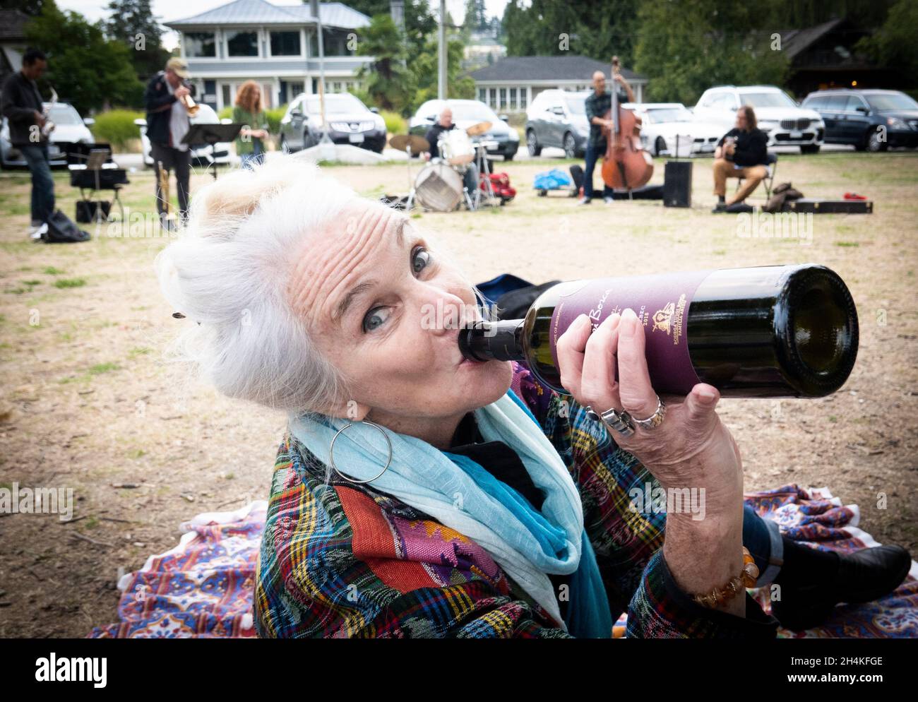 Una mujer de 70 años bebe vino en Locarno Beach, Vancouver, BC, Canadá. Foto de stock