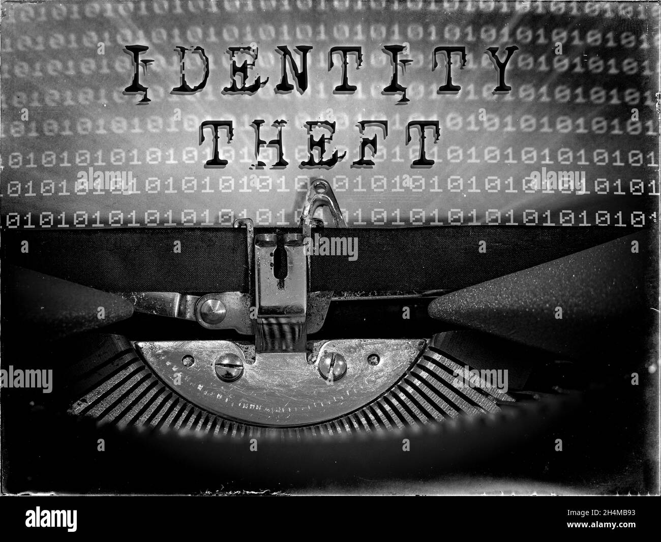 El robo de identidad se muestra en una máquina de escribir vintage con un fondo de código binario Foto de stock