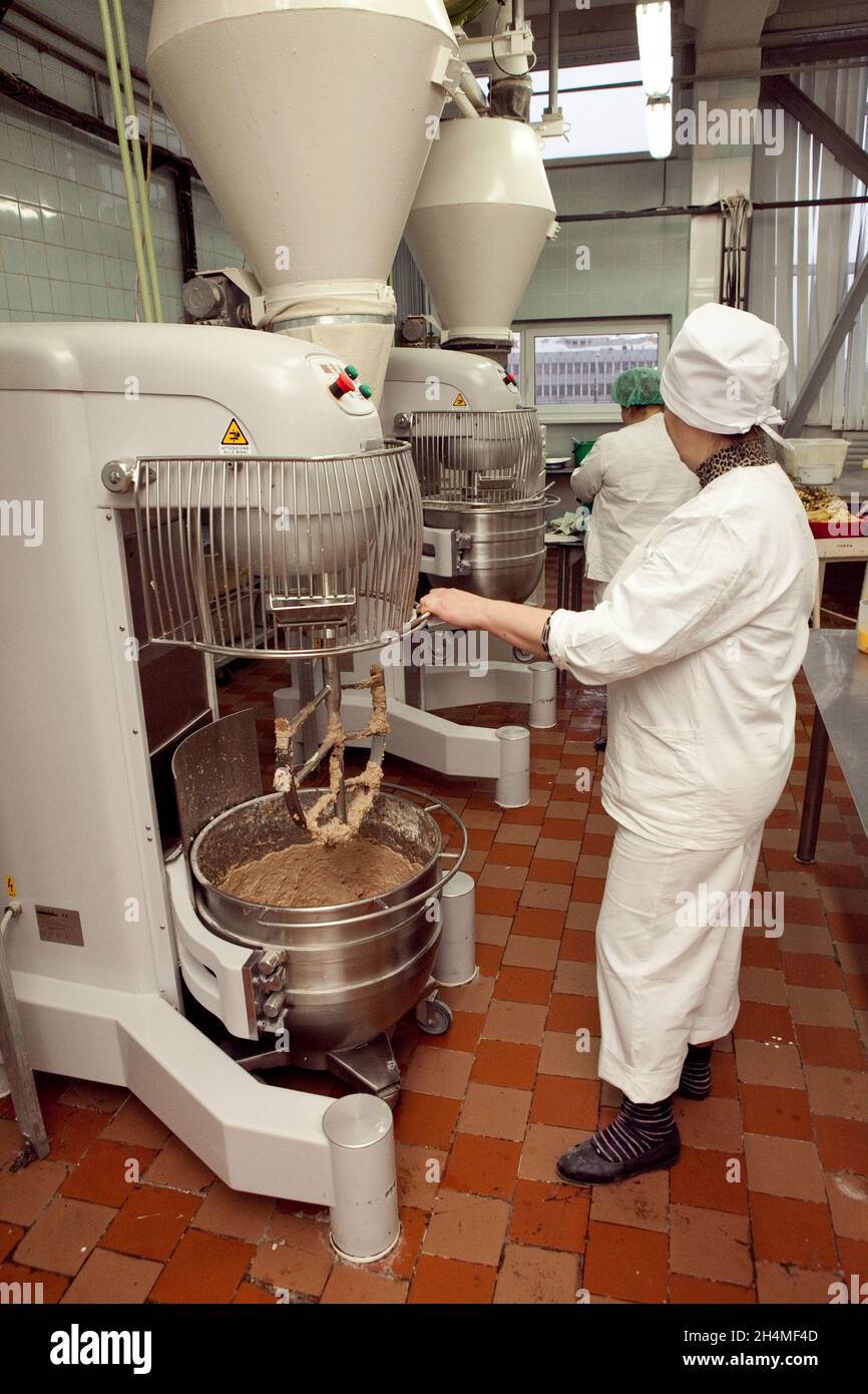 El proceso de hacer masa de galletas en una máquina de amasar industrial en  la fábrica Fotografía de stock - Alamy