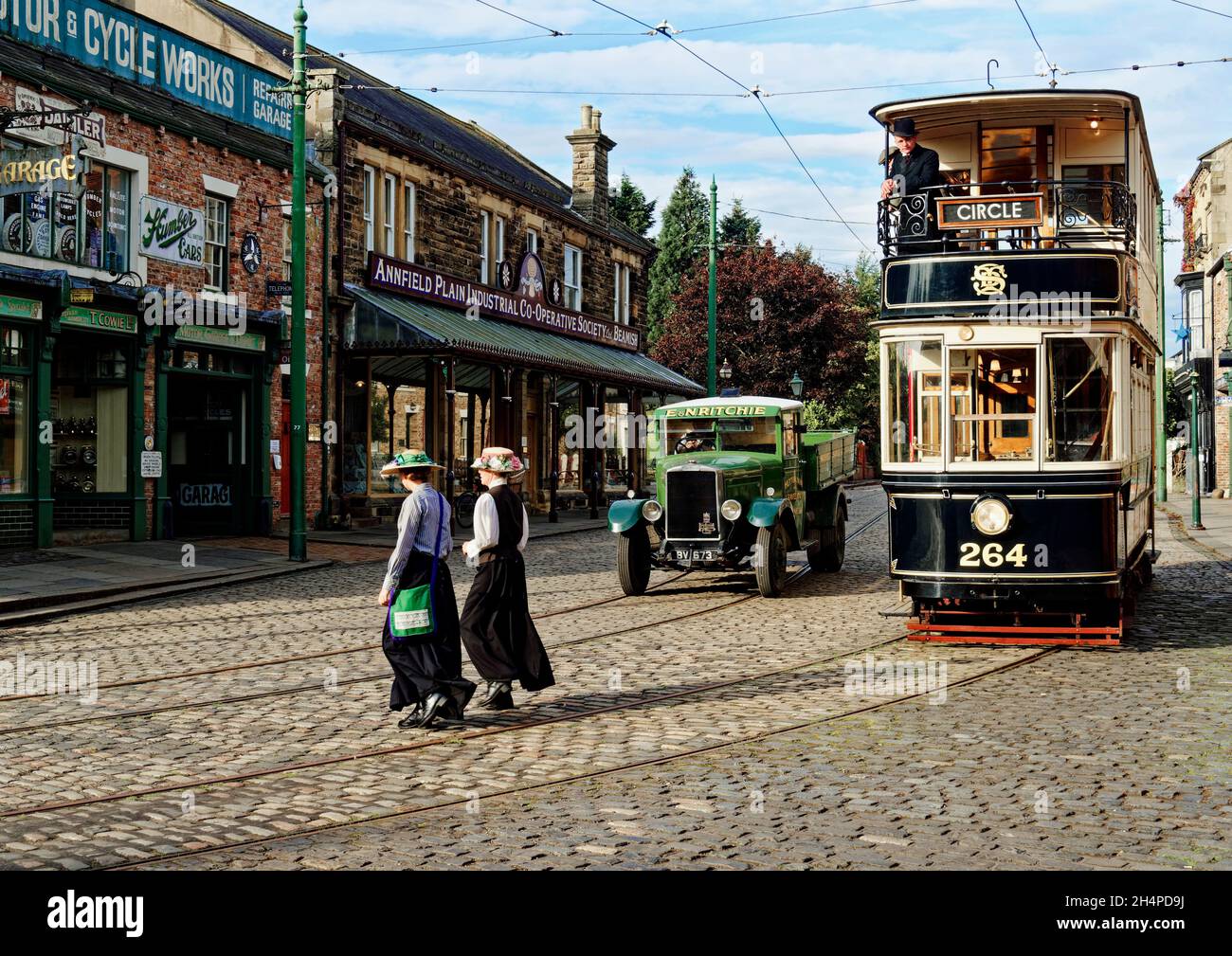 El tranvía de Sheffield restaurado recrea una escena callejera de 1900 con personas en trajes de época en la zona de la ciudad del Museo Beamish, Condado de Durham. Foto de stock