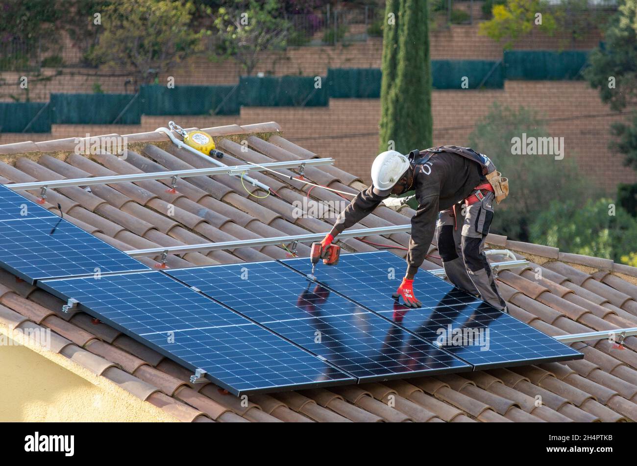 Los trabajadores con contrato eléctrico de HolaLuz instalan paneles solares  en el techo de una casa residencial durante la instalación de un sistema de  suministro eléctrico subvencionado para viviendas privadas, al norte