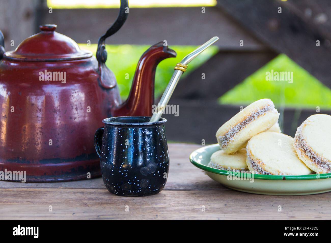 Mate y hervidora con un plato de alfajores argentinos e infusión de yerba mate Foto de stock