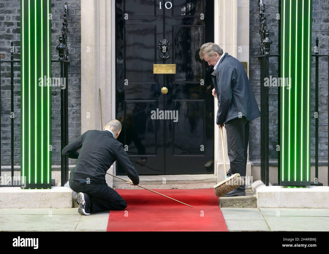 Londres, Inglaterra, Reino Unido. Hombres quitando la alfombra roja de los escalones de 10 Downing Street después de una visita VIP. (Rey de Jordania, octubre de 2021) Foto de stock