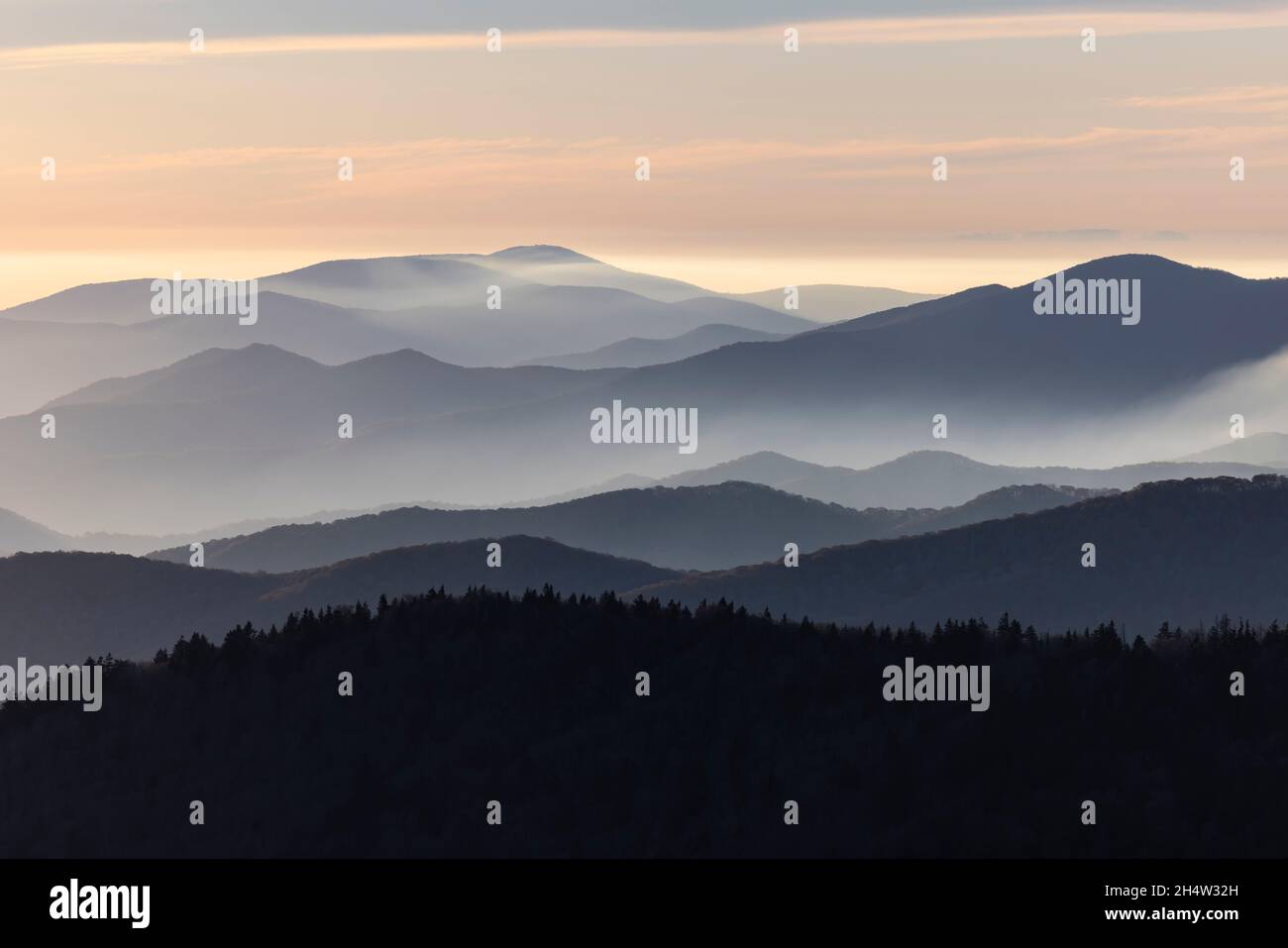 Una vista clásica de las nubes que se extienden sobre capas de montañas rocosas poco antes de la puesta de sol en el Parque Nacional Great Smoky Mountains. Foto de stock