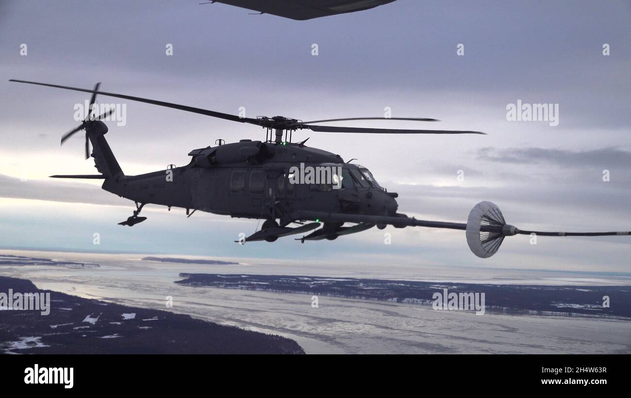 Los miembros de los escuadrones de rescate de 210th y 211th, de la Guardia Nacional de Alaska, practican el reabastecimiento aéreo en un helicóptero HH-60G Pave Hawk sobre Alaska el 21 de enero de 2021. Esta práctica ayudó a preparar a los miembros de la unidad para ejecutar futuras misiones de rescate. (EE.UU Foto de la Guardia Nacional Aérea del personal Sgt. Kelly Willett/Lanzado). Foto de stock
