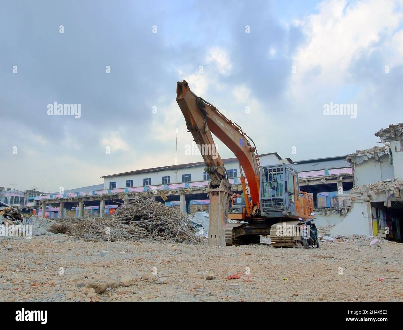hay una excavadora delante del edificio lista para ser demolida Foto de stock