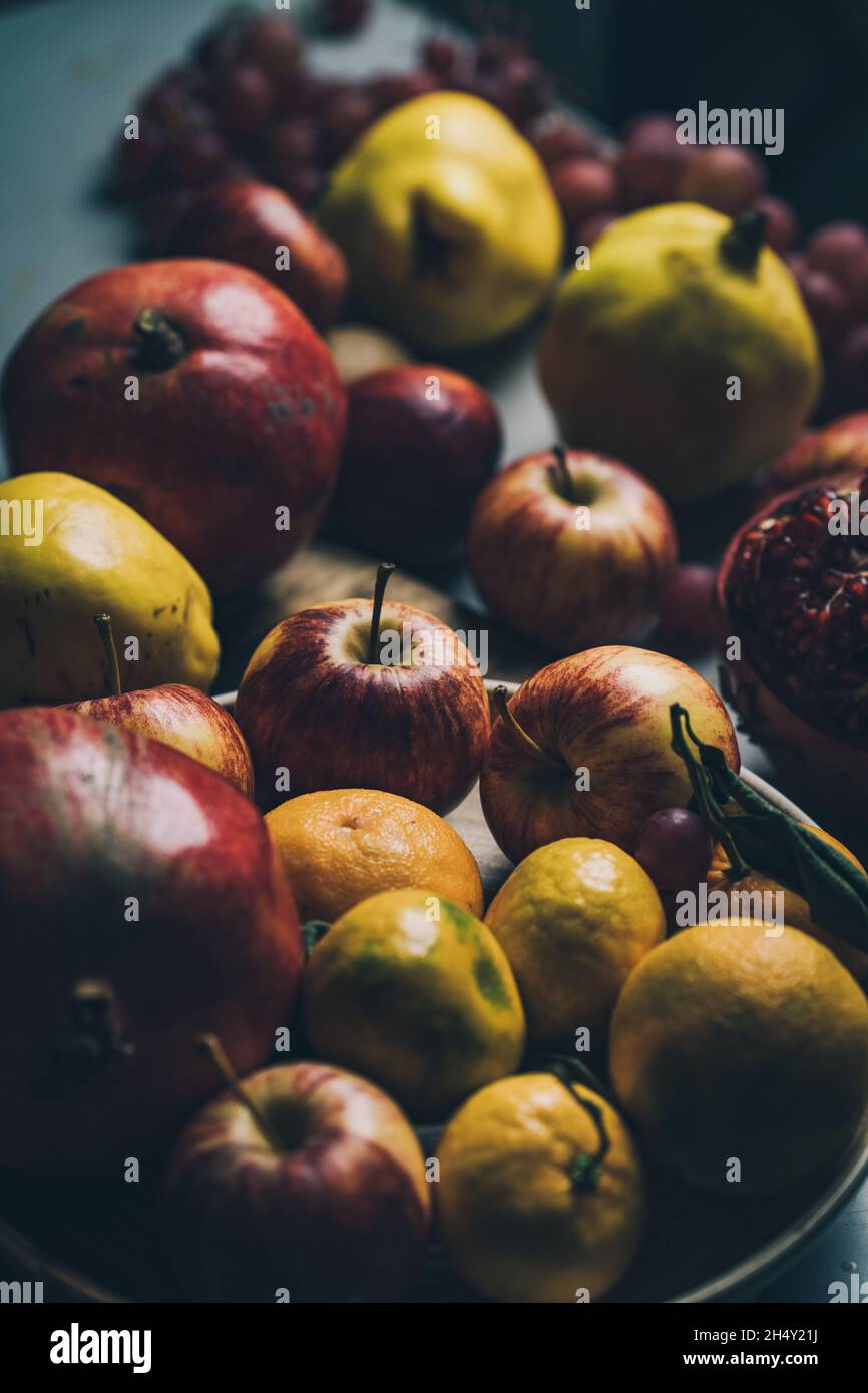 Fotografía de la vida de las frutas y las flores de estilo barroco oscuro y renacentista. Manzanas, uvas, granada, membrillo. Foto de stock
