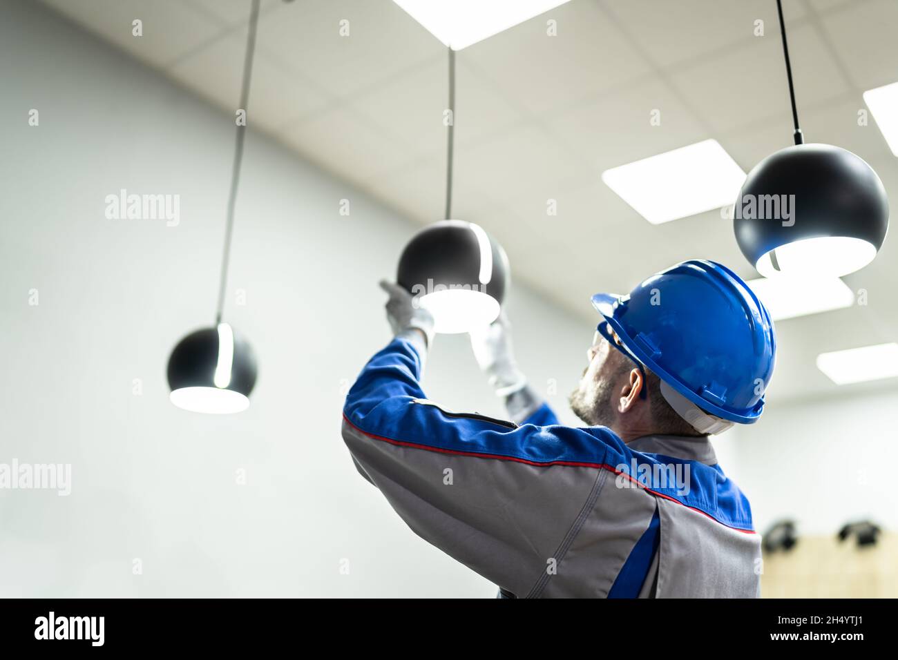 Mantenimiento de equipos de iluminación de techo para el hogar. Trabajador  Electricista Profesional Fotografía de stock - Alamy