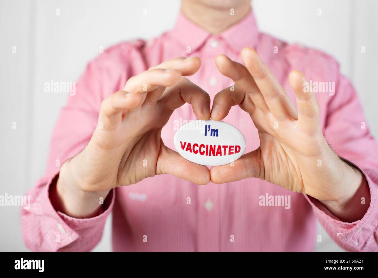Alfiler 'Estoy vacunado' en forma de corazón formado por dedos Foto de stock