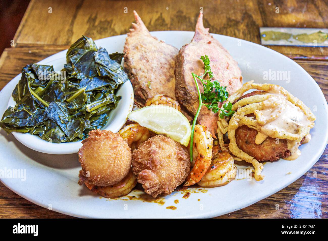 Charleston South Carolina, Meeting Street, restaurante Hyman's Seafood, comida, plato plato, cangrejo, hacha, cachorros, col, greens, camarones y sémola Foto de stock