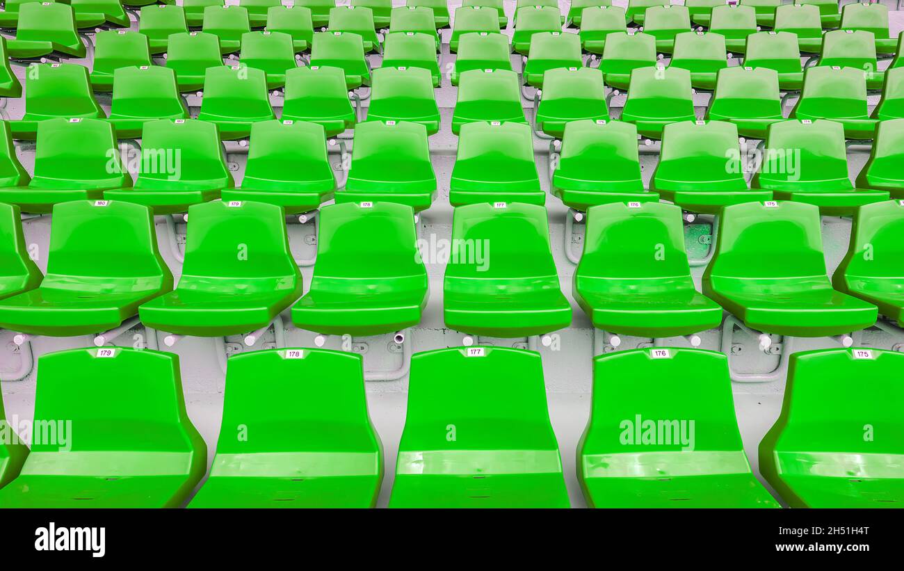 Asientos de estadio numerados de color verde vacíos Foto de stock