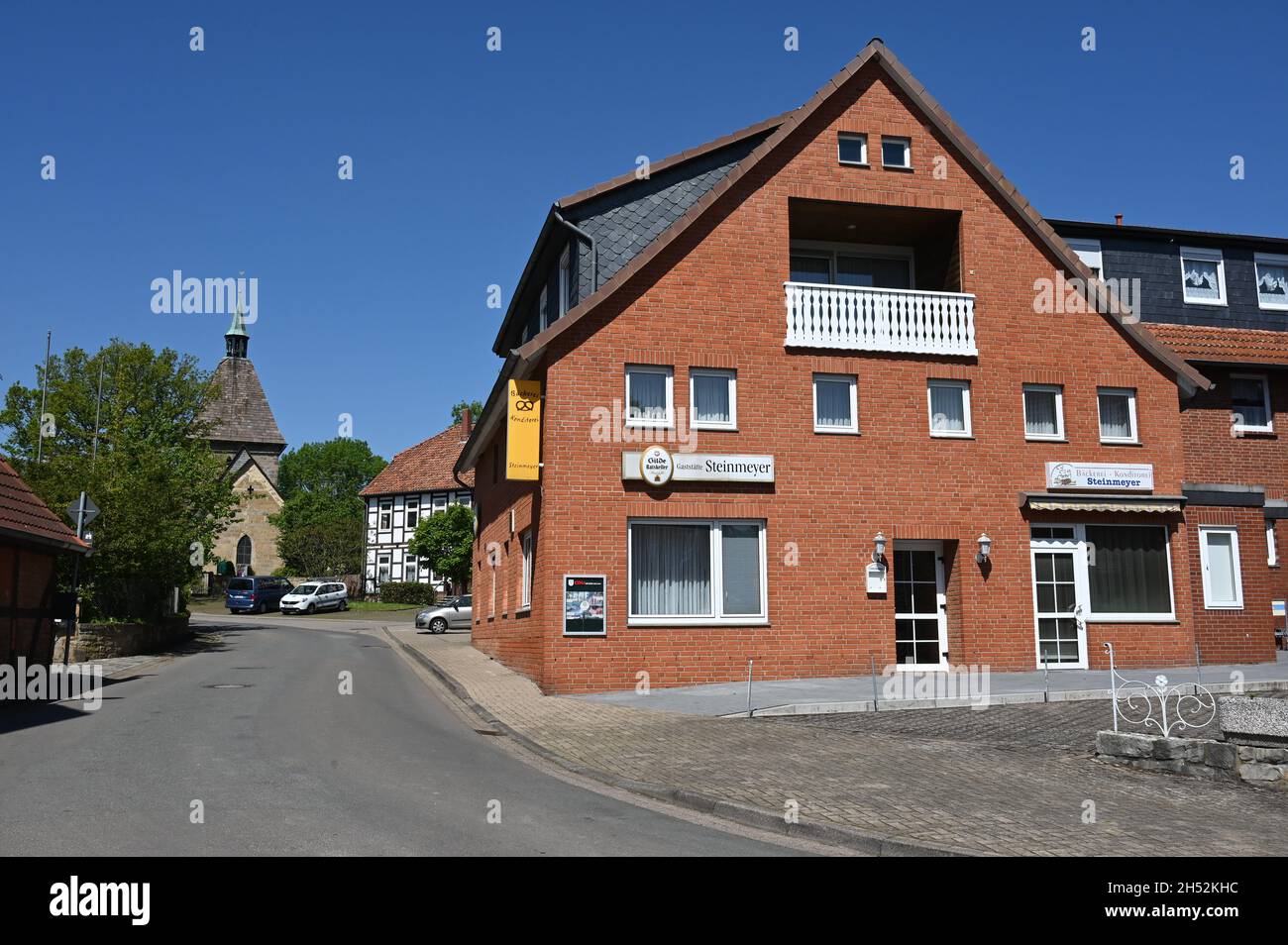 Calle del pueblo en Hülsede con restaurante e iglesia en el distrito de Schaumburg Foto de stock
