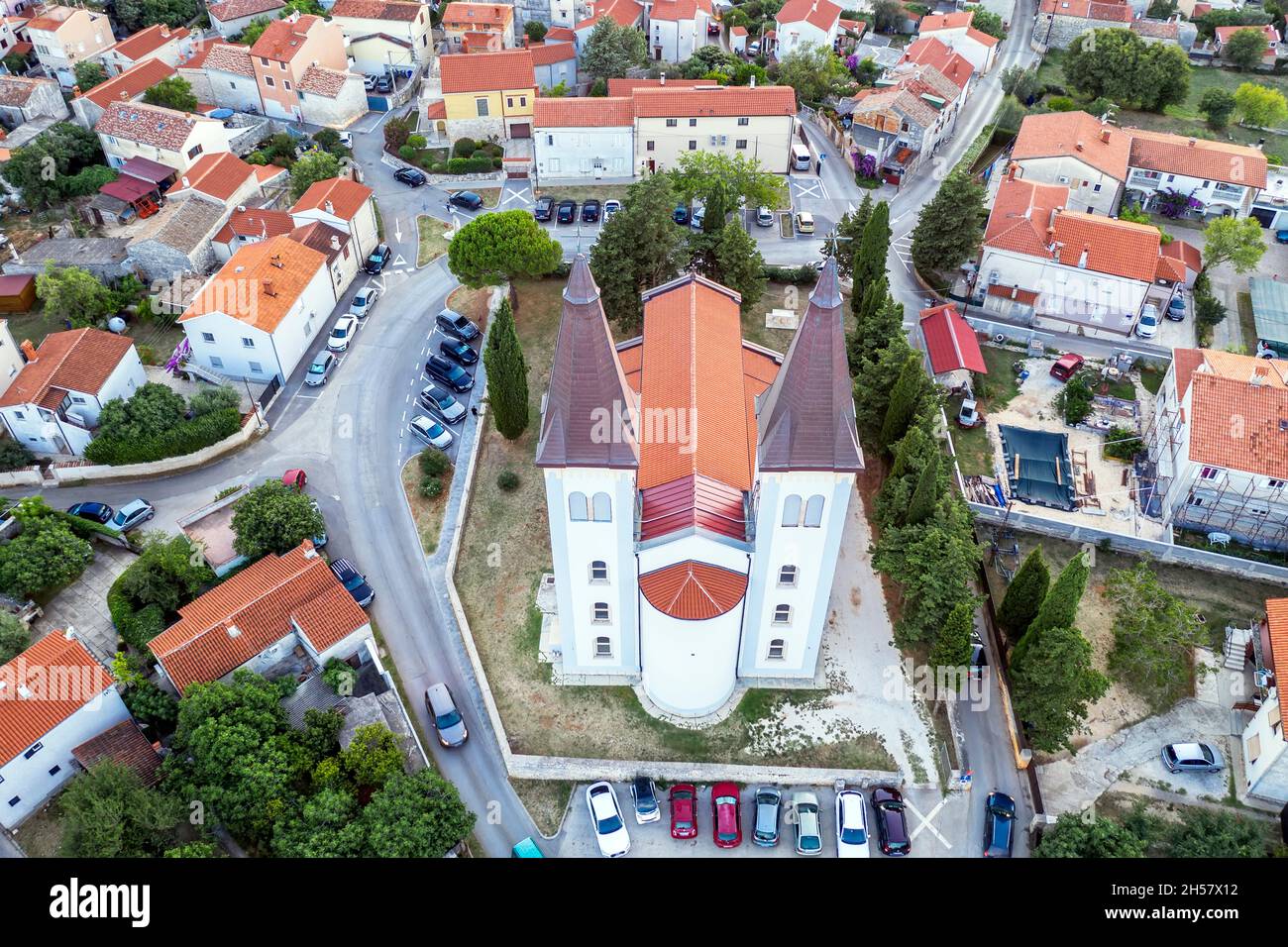 Una iglesia aérea de tiro de Sv. Agnes con dos campanarios de 33 m de altura, en Medulin al atardecer, Istria, Croacia Foto de stock