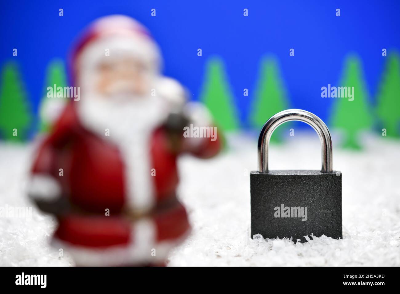 Weihnachtsmannfigur und Vorhängeschloss, Symbolfoto Corona-Weihnachten und Lockdown Foto de stock