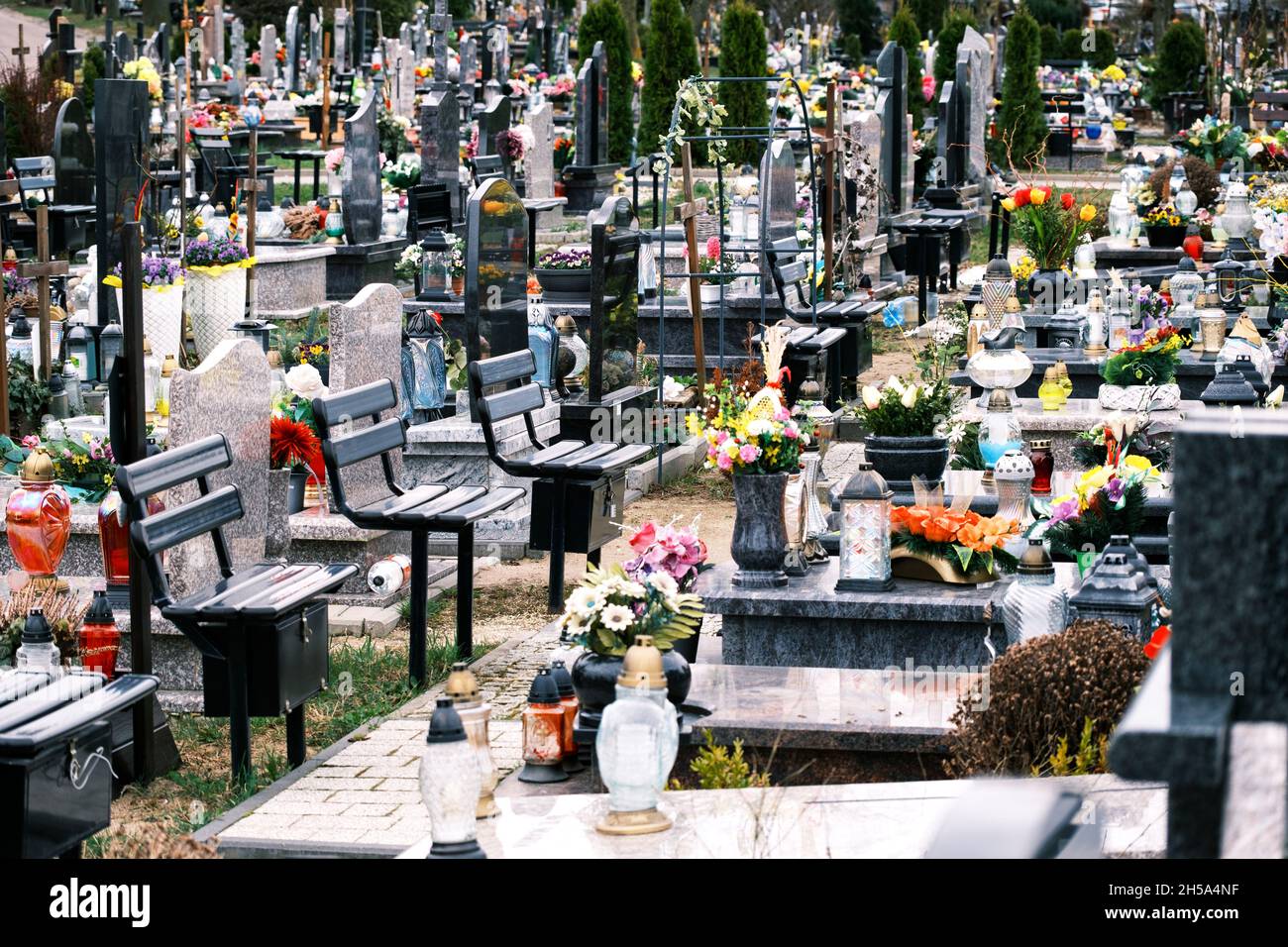 Cementerio en Polonia - filas de monumentos con cruces, flores y velas Foto de stock