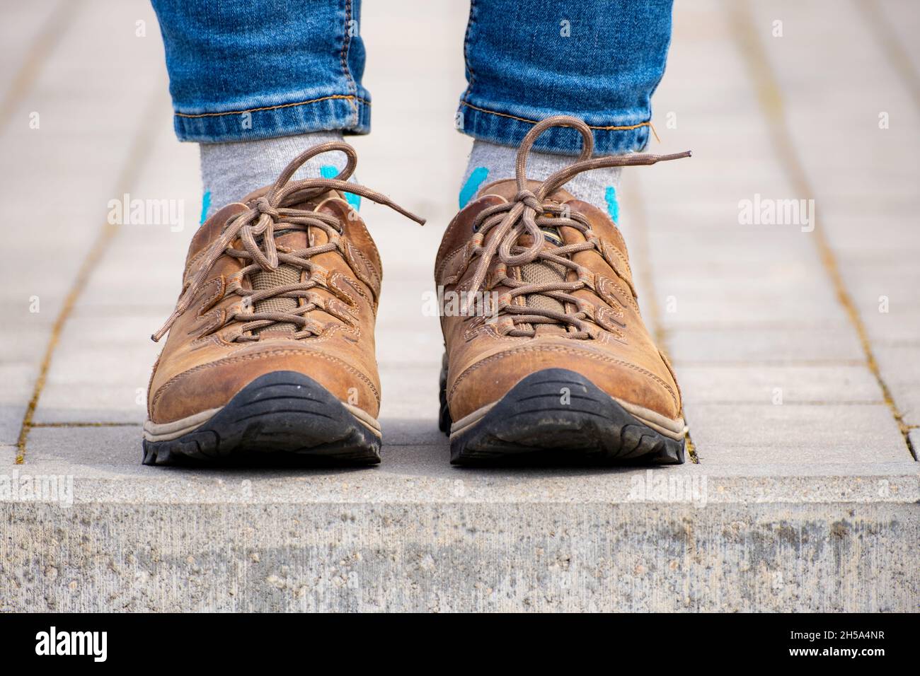 jeans azules y zapatos de cuero marrón - pronación en el pie Foto de stock