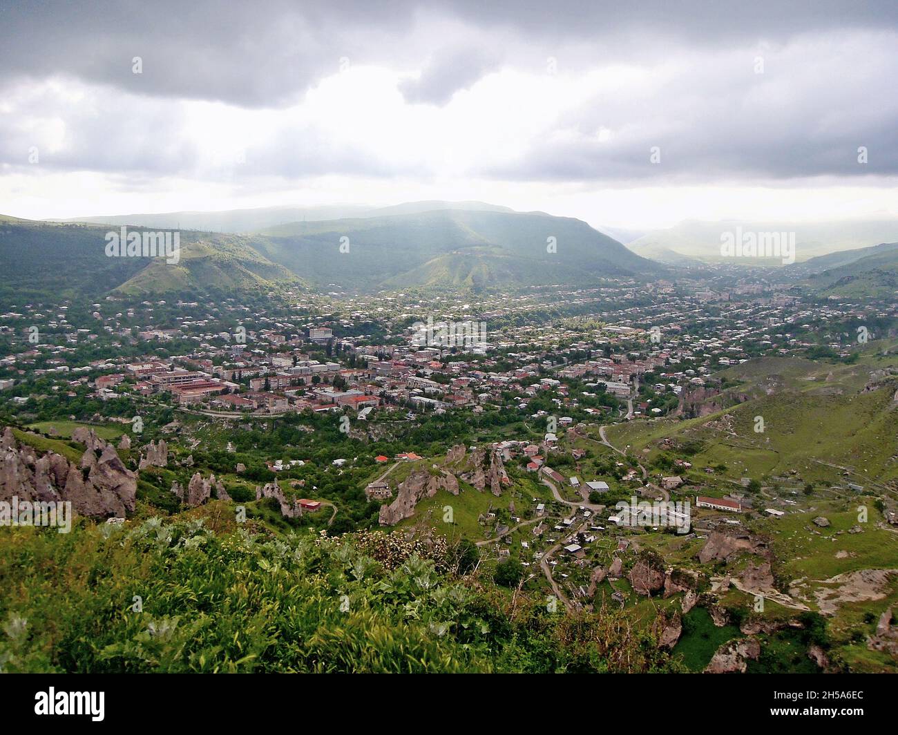 Vista panorámica de Goris, Armenia, al atardecer desde lo alto de las colinas que rodean la ciudad. El frente de la foto es parte del parque geológico, llamado Bosque de Piedra. Zan Foto de stock