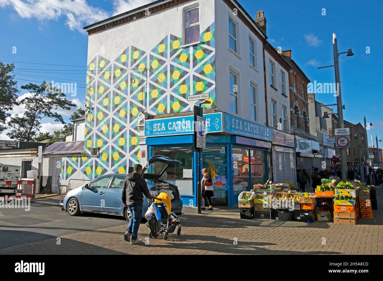Walthamstow High Street pintura geométrica de la pared en el edificio, tiendas, mercado de verduras de frutas en el sol de otoño octubre 2021 Londres Reino Unido KATHY DEWITT Foto de stock