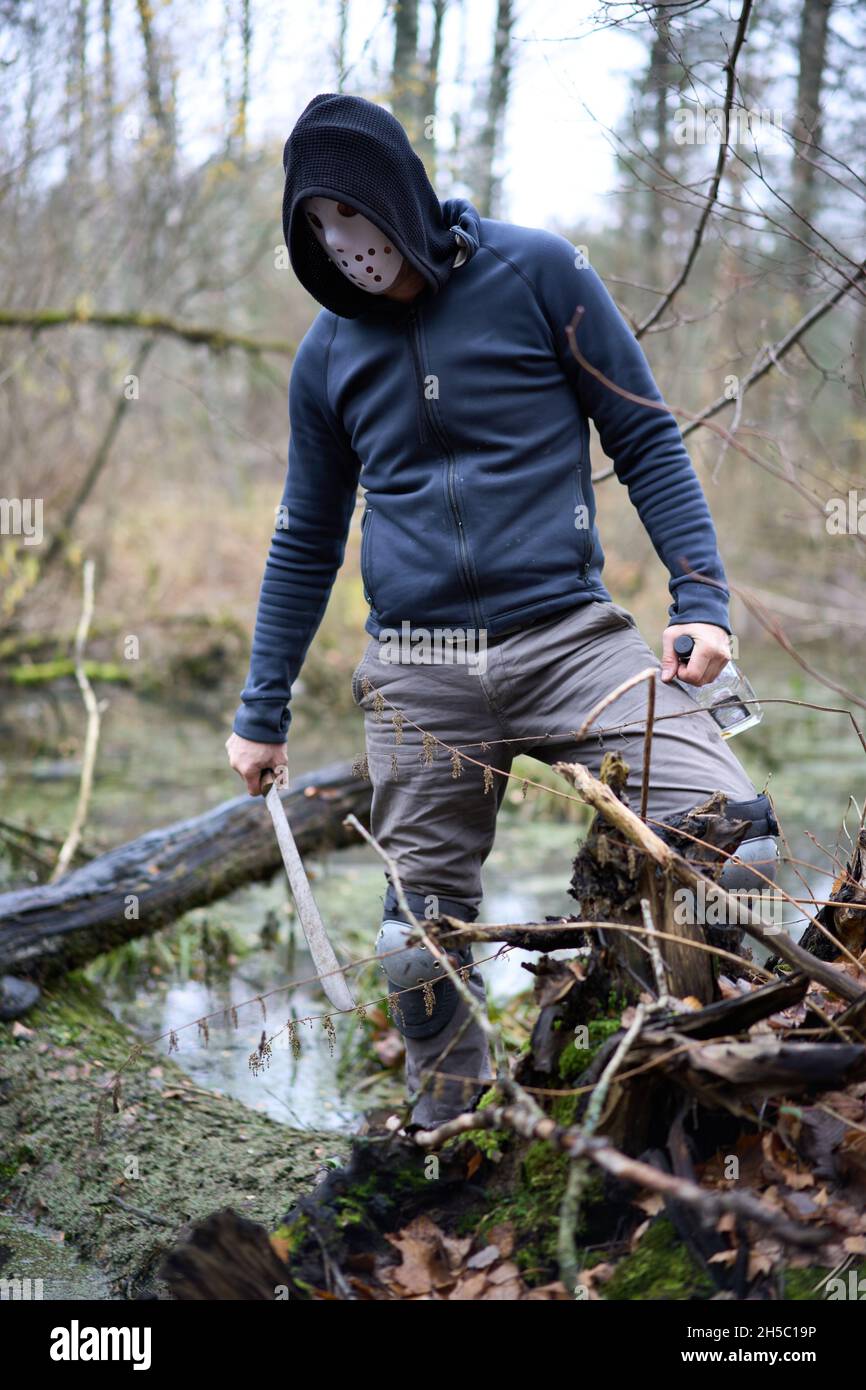 Serie asesino Jason Voorhees en máscara de hockey y machete permanecer en  el pantano en el bosque de otoño. Viernes 13h traje de cosplay Fotografía  de stock - Alamy